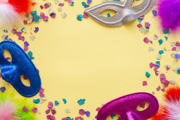 Purim carnival yellow background with colorful confetti, and blue, grey and purple glitter mask