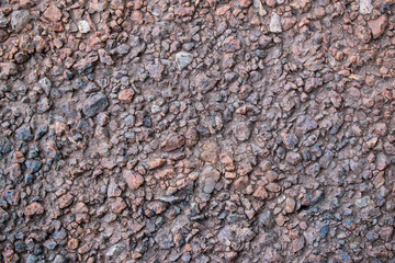 Surface with small sharp stones for a backdrop. Colors are brown and gray. Concept of stone skin.