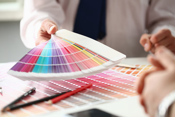 Employee refueling cartridge service holds magnifying glass in hand. Color print of pantone...
