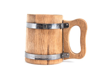 Wooden beer mug stands on a table on a white background sideways.