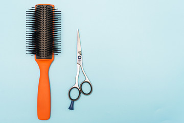 Professional black comb and scissors. Hairdresser tools on a blue pastel background