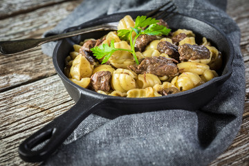 Italian pasta shells with beef sauce in cast iron pan.