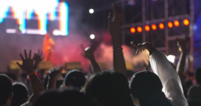 people watch band performing on the stage on music festival young people waving hands enjoy the rap music live show