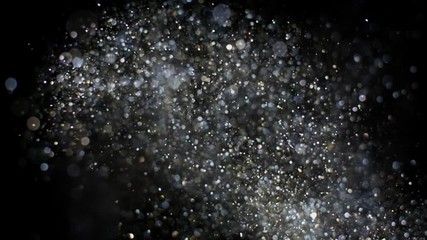 Gold and silver glitter flying after being exploded, bright sparkles bouncing against camera flying and falling down on black background. Top view close up macro slow motion - Powered by Adobe