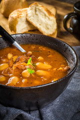Beans with tomato sauce, bacon and sausage.