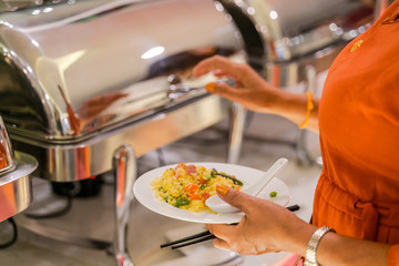 Woman hand taking food in buffet