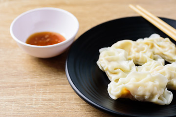 Steamed wonton dumpling stuffed with minced pork and shrimp eating with sesame oil sauce, Asian food