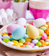 Bright colored eggs, large and small for Easter Sunday. Traditional treats on a round platter. Copy space
