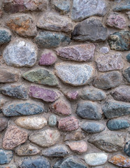 texture. a wall or road made of multi-colored cobble stones.