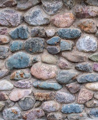 texture. a wall or road made of multi-colored cobble stones.