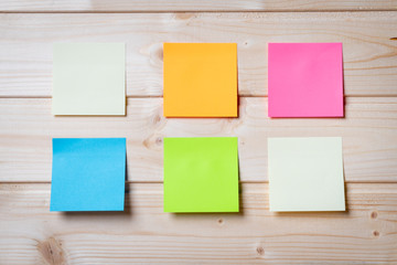Group of colorful sticky notes on a wooden wall - Copy space