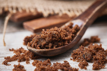 Dark muscovado sugar, also called Barbados sugar, khandsari, or khand, in wooden spoon