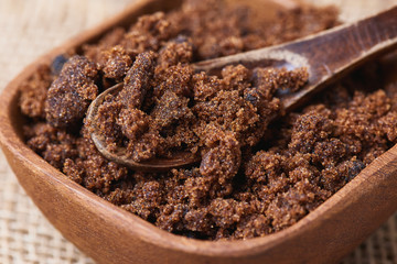 Dark muscovado sugar, also called Barbados sugar, khandsari, or khand, in wooden spoon