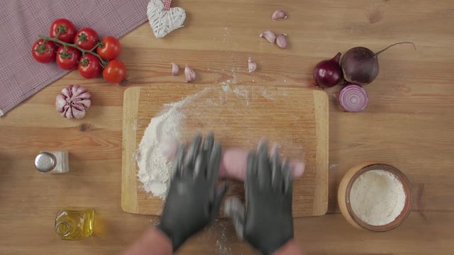 Cooking vegetarian snack food table top still life cook black gloves pink dough tomatoes beetroot flour garlic onion oil