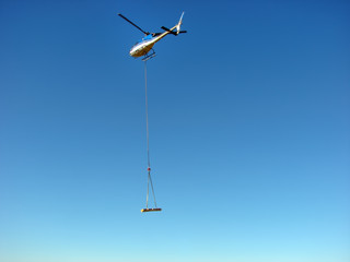 Fototapeta na wymiar Helicopter transports a wood beam