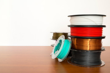 3D printing filament reels isolated over white and wooden background