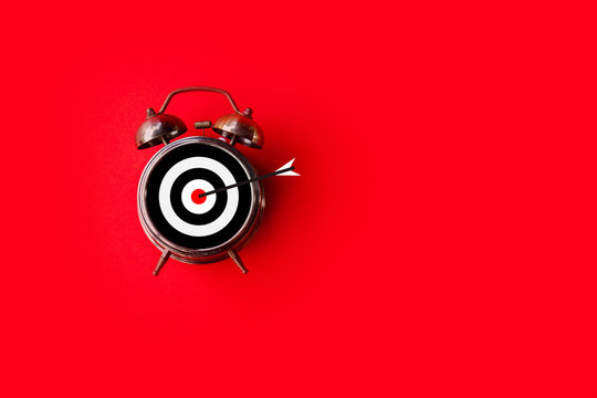 target time, goal sign on clock face over red background with copy space 