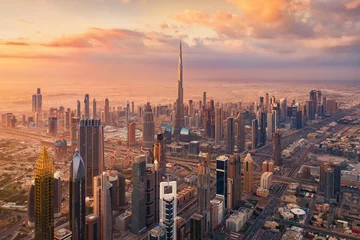 Wandaufkleber Aerial view of Burj Khalifa in Dubai Downtown skyline and highway, United Arab Emirates or UAE. Financial district and business area in smart urban city. Skyscraper and high-rise buildings at sunset. © tampatra