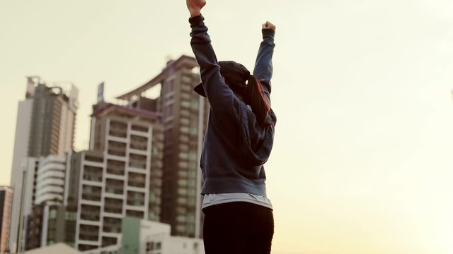 Girl raised her hands up at a training on the road in the city.