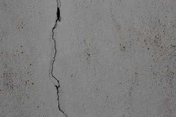 Gray weathered plaster wall with a crack running through it as white background