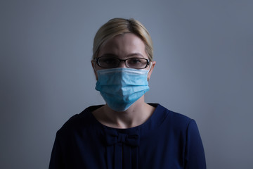 an attractive young woman wears a paper face mask to protect herself from the H1N1 Virus, isolated on white, with room for your text
