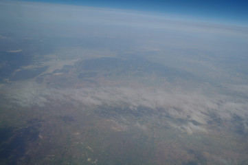 View from the plane window to the clouds and the earth