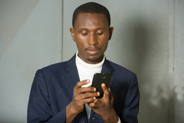 man in jacket typing something on a cell phone