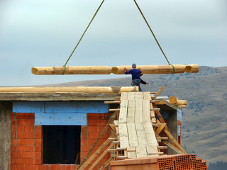 Naklejka premium Workers fix the beam on the construction