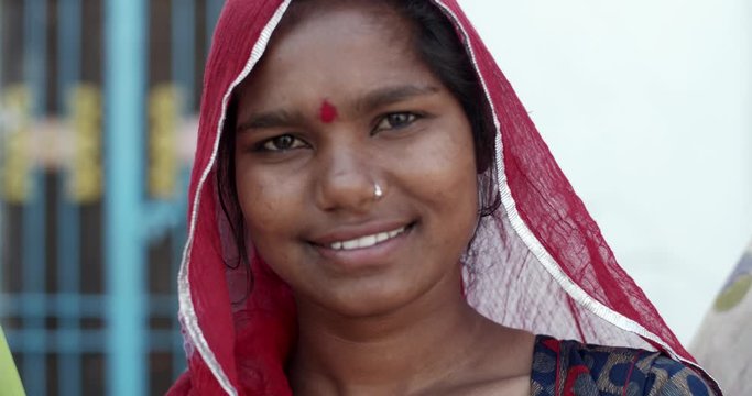 Close-up of an confident positive happy Indian teenage girl wearing salwar kameez, traditional dress with head covered in Rajasthan, looks smiles and thumbs up at camera smiles- handheld slow motion