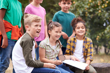 Group Of Children On Outdoor Activity Camping Trip Looking At Map Together