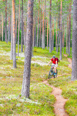 Woman riding her mountainbike down a forest path