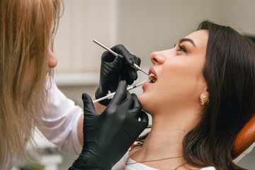 dentist gives anesthesia shot to patient
