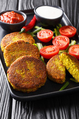 Baya Kyaw Burmese style falafel made of yellow split peas with fresh vegetables and sauces close-up in a plate. vertical