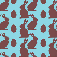Chocolate rabbits and Easter eggs on blue background. Seamless pattern. Vector illustration .