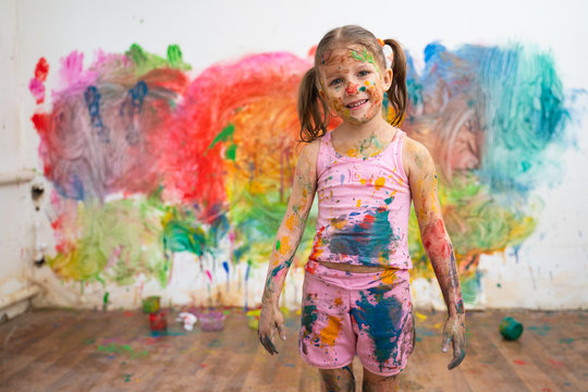 Little Girl Child Preschooler Draws Hands Paints On White Wall.