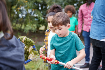 Naklejka premium Group Of Children On Outdoor Activity Camp Catching And Studying Pond Life