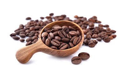Coffee beans in a wooden spoon on white background.