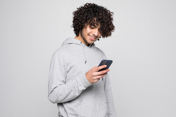 Portrait of handsome curly man holding phone isolated on white background