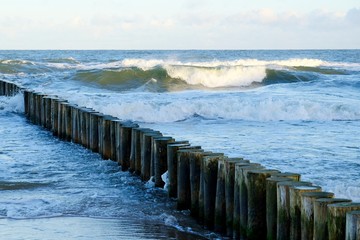 Waves crashing on the breakwater on a sunny day. Baltic Sea coast, Dziwnowek, Poland