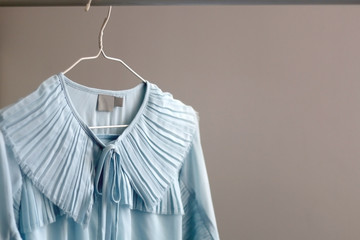 Feminine light blue dress on a clothing rack. Selective focus.