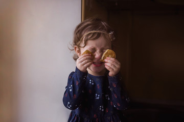 The girl closed her eyes with pancakes. Fun in the kitchen.