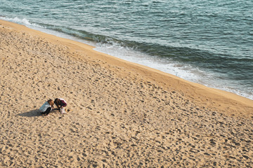 Two girls playing on the beach. Barcelona, Spain.