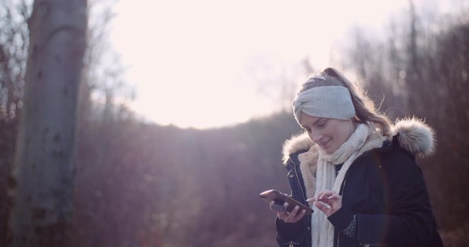 Technology - woman using smartphone to take picture in autumn
