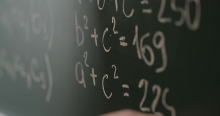 Human hand writing math formulas on school blackboard, lesson - Powered by Adobe
