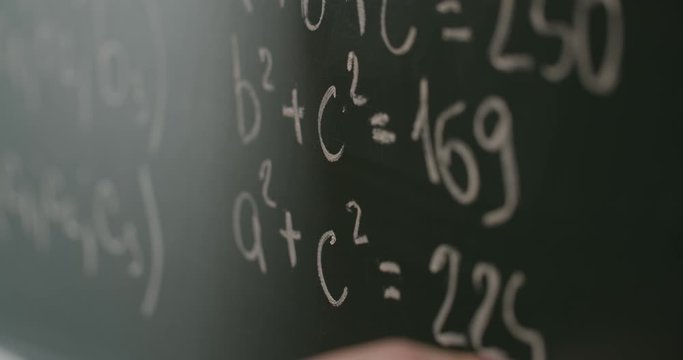 Human hand writing math formulas on school blackboard, lesson - Powered by Adobe