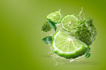 Fototapeta na wymiar Water splashing on Bergamot fruit on green background