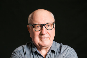 Portrait of elderly man on dark background