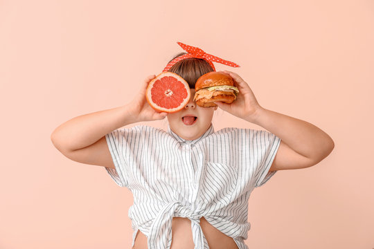 Overweight girl with healthy and unhealthy food on color background