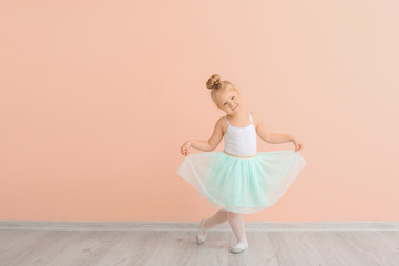Cute little ballerina near color wall - obrazy, fototapety, plakaty