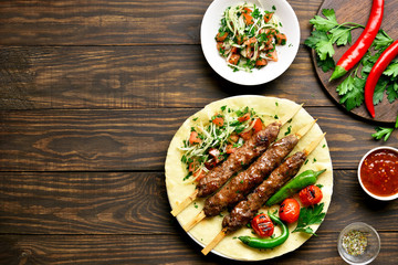 Turkish Adana Kebab with fresh vegetables on flatbread